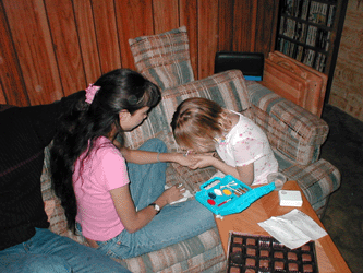 Amanda painting a flower on her cousins hand on March 24, 2002
